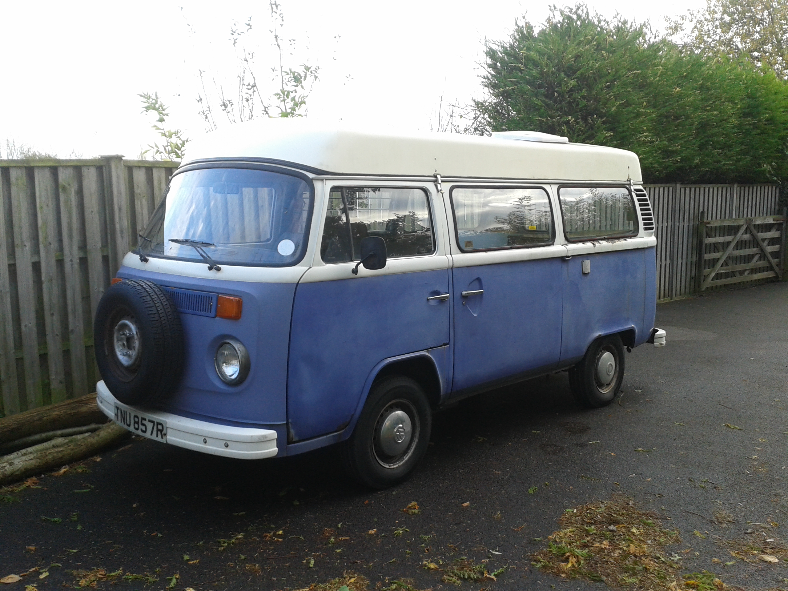 Rusty VW camper van sitting in driveway